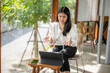 © Apichat - woman is sitting in a chair with a laptop in front of her