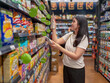 © Apichat - woman is shopping in a grocery store and is looking at a box of cereal