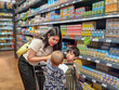 © Apichat - woman is shopping with two children in a grocery store