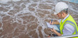 © reewungjunerr - Engineer inspecting wastewater treatment process at a facility. Professional quality control and environmental monitoring in industrial water recycling systems.