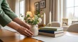 © Kristina - Woman arranging decorative bird on dining table, setting out plates for meal prep. Home decor and domestic scene.