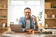 © Miljan Živković - Happy entrepreneur showing credit card while working from home