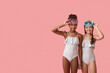 © Pixel-Shot - Cute little girls in swimsuits with snorkelling masks  on pink background