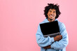 © Prostock-studio - Cool African American teenager in casual wear hugging laptop pc with mockup for design on empty screen over pink studio background. Space for your website or online advertisement