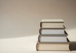 © tebu - A stack of four neutraltoned hardcover books sidebyside against a soft background