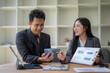 © Apichat - Business people working together using digital tablet and documents discussing financial chart showing growth