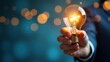 © Imperion - A glowing lightbulb held in a hand, symbolizing new ideas and innovation against a backdrop of soft bokeh lights.