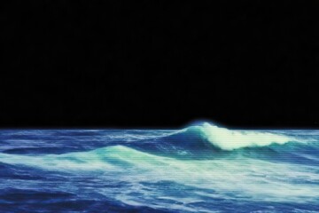 Canvas Print - An ocean scene with a single breaking wave against a dark sky