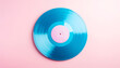 © Felynamanoppo - Vibrant teal-colored vinyl record on a pastel pink background.