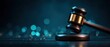 © Alohanongza - A wooden judge’s gavel rests on a sound block against a dark, blurred background with blue bokeh lights