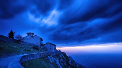 Canvas Print - Dramatic twilight scene of ancient stone buildings atop a hill with swirling clouds and distant horizon