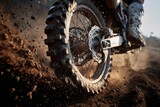 Close up of a motocross bike tire kicking up dirt The bike and rider are in motion