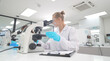 © FotoArtist - Scientist examining samples under microscope in a modern laboratory setting