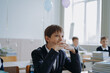 © Yulia Raneva - teen age boy wearing uniform sitting at the class in school.