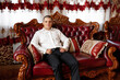 © Vasil - Man poses elegantly in formal attire on ornate couch in a stylish interior setting
