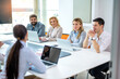 © Bojan - Business people sitting with laptops around conference table in meeting room