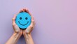 © Plake - Hands holding a blue smiling face on the left, with ample blank space on the right for copy, symbolizes mental health, positivity, growth, and recovery.