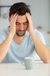 © auremar - young man having breakfast unhappy and frustrated