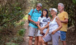 © luciano - Trekking day in the forest for a happy group of seniors in friendship walking in outdoor excursion enjoying nature and healthy lifestyle in vacation or retirement