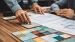 © fivan - A tile design meeting or consultation, hands pointing at architectural drawings and ceramic samples, wood table, storytelling composition