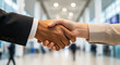 © Visual Wit - Professional business handshake between diverse partners in a modern lobby