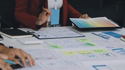 group of young application developers analyzing uxui mobile app templates during a working meeting