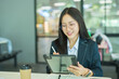 © maeching - Happy successful female bank manager or businesswoman or female entrepreneur holding digital tablet standing in modern office workplace.