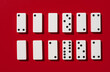 © Maryam - Arrangement of white domino tiles with black dots on a red background