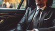 © FS - Sophisticated Travel: A well-dressed individual in a tailored suit enjoys a luxurious ride in a car's refined interior, epitomizing the essence of elegance and the comfort of premium transportation.