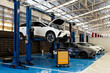 © memorystockphoto - Electric car on hydraulic lift in modern auto repair workshop