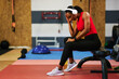 © djile - Tired black woman resting after fitness training in gym