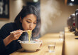 © tennen - ラーメンを食べる女性