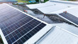 © ultramansk - erial drone view of workers installing solar panels on a factory rooftop. The team is building a new power system that uses the sun to create clean, green energy for the future.