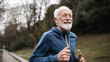 © Kanlayarawit - Elderly man jogging in the park, wearing blue sportswear, healthy lifestyle concept.