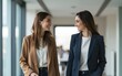 © li - Two business casual businesswomen walking in office and discussing project. High quality