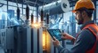 © Pixcellence - Engineer monitoring high voltage electrical substation with digital tablet for industrial safety and efficiency