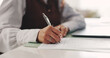 © peopleimages.com - Contract, hands and signature with business woman at desk in office to sign draft or proposal. Compliance agreement, documents and legal paperwork with employee writing for management approval