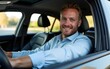 © car - Portrait of a happy business casual man sitting in his classy car and smiling at camera. High quality