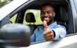 © guo - Happy black car driver is driving his classy car and giving thumbs up at camera. High quality