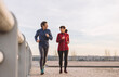 © Westend61 - Mature man and woman running on sunny day