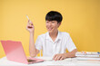 © Q88 - A joyful student smiles pen in hand amidst a learning setup against a sunny yellow backdrop