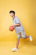 © Q88 - Enthusiastic young player in athletic attire poses with a basketball on a vivid backdrop