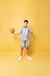 © Q88 - Youthful Athlete Poses with Confidence Sporting Basketball Uniform and Holding Ball in Hand