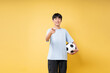 © Q88 - Enthusiastic youth with soccer ball pointing at the viewer Ready for action and having fun