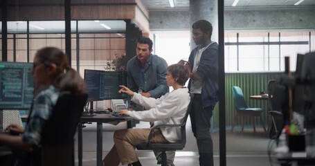 Team of Three Talented Software Engineers Use Computer to Discuss a Technological Project in Modern Industrial Office. Group of Male and Female Programmers Work in Research and Development Center