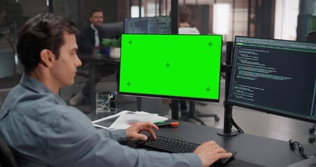 Software Developer Working on Computer with Green Screen Mock Up Display, Writing Source Code for an App in Office. IT Programming Department Researching and Developing Online Software