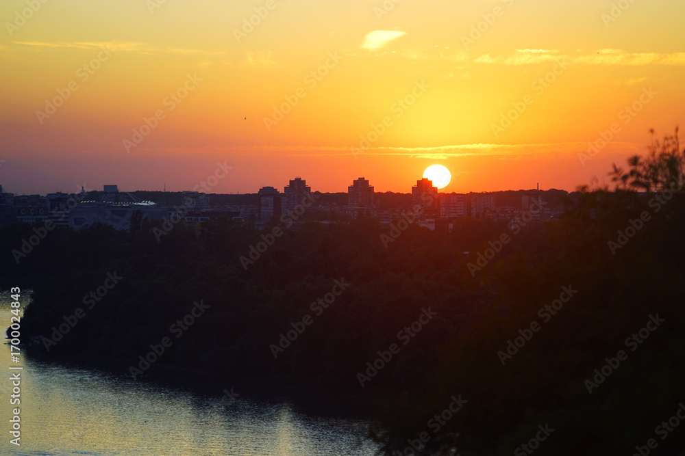 Sunset from Kalemegdan: view of the Danube, sun setting on the horizon, multi-story buildings and colorful sky. Slow travel inspiration,  evening atmosphere and mindful living in modern environments