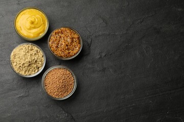 Wall Mural - Different types of mustard on black table, flat lay. Space for text