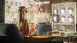 © Gorodenkoff - Woman Sitting on a Sofa at Home, Using Virtual Augmented Reality Headset to Create a Female Avatar. She is Using Controllers, Choosing a Hairstyle, Changing Color Until Finding a Best Match