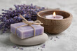© Denis - Organic bar of homemade soap tied with twine, Levander flowers around and lit candle. Natural environmentally friendly hygiene.
